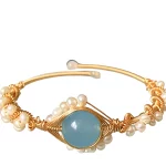Ce bracelet de perles et saphir est incrusté de cristaux de saphir qui ajoutent une touche de couleur et de brillance à l'ensemble.